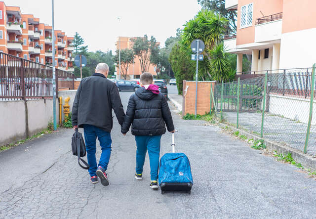 Oleksandr and Sasha walk along, holding hands.